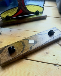 Adjustable Jacobean-stained wood stand with metal clamps holding a stained-glass panel