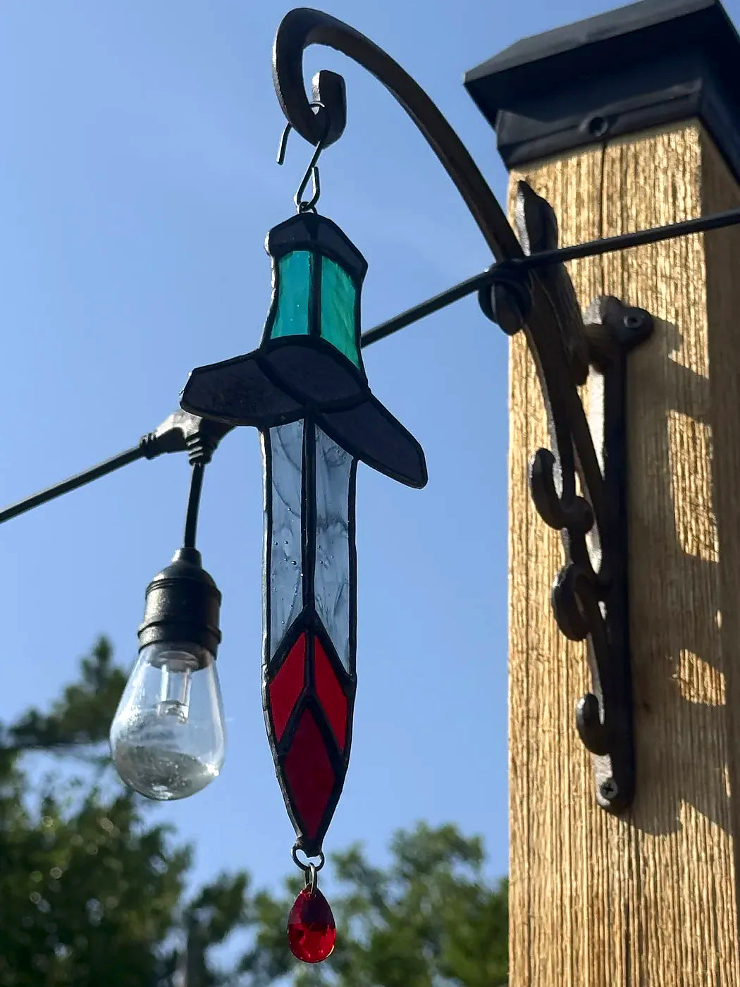 Close-up of the blue-grip Bloody Dagger stained-glass suncatcher with clear smoky blade and red crystal