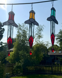 Bloody Dagger stained-glass suncatcher with clear blade, black spade guard, red chevron, and crystal teardrop