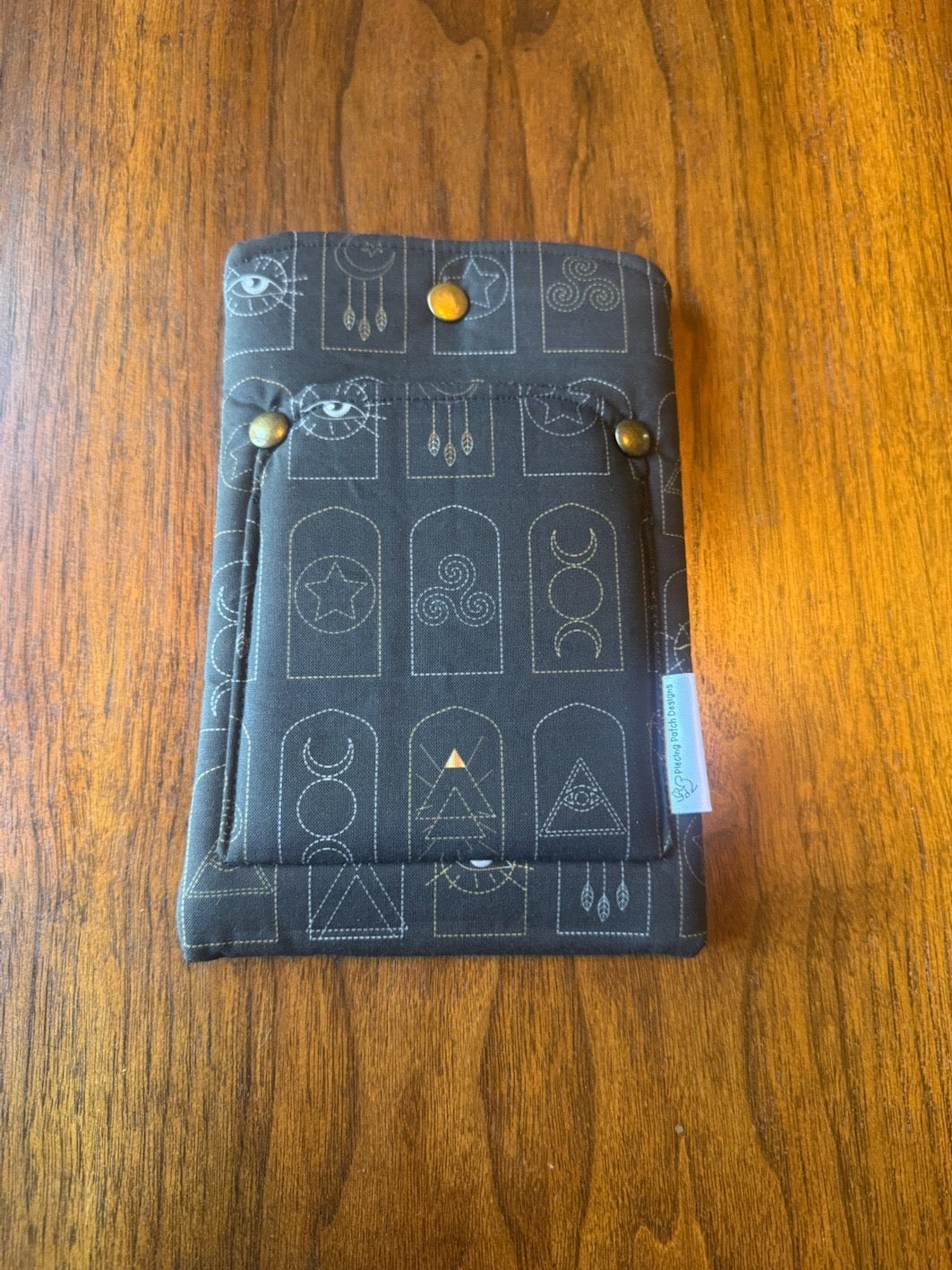 Small padded fabric device sleeve with Arched Mystic Symbols design, shown upright