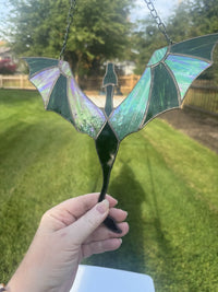 Dragon in Flight stained glass suncatcher in green with iridescent wings, held up in the sun