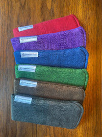 Group of padded solid-color fabric eyeglass cases with built-in lens cloths