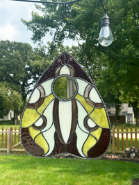 Close-up of the luna moth and mirrored center in the stained-glass planchette