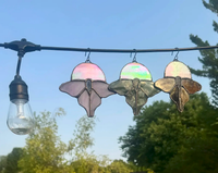 Luna moth stained-glass suncatcher shown with iridescent moon accent