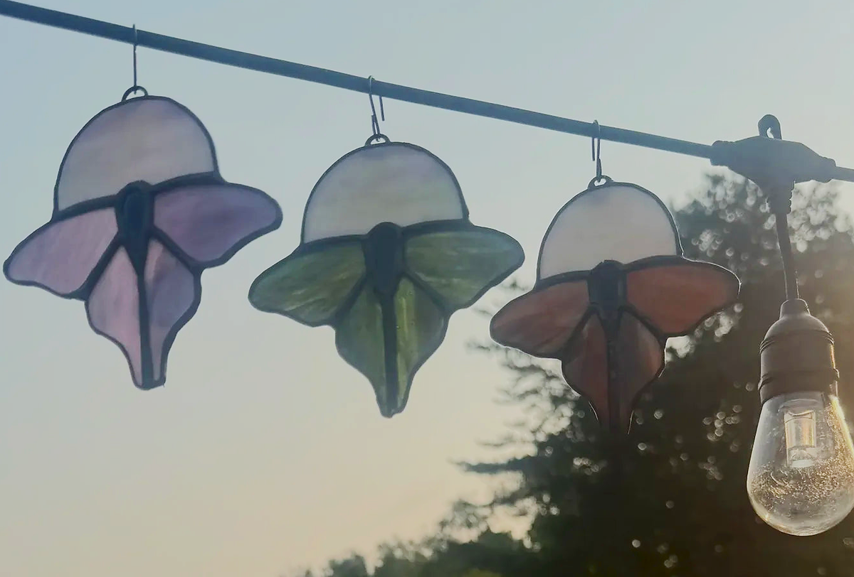 Close-up of the iridescent moon accent in a luna moth stained-glass suncatcher