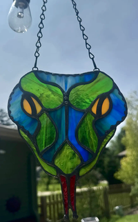 Blue snake-head stained-glass suncatcher with yellow eyes and forked red tongue