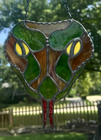 Close-up of the brown snake-head stained-glass suncatcher with layered textured glass